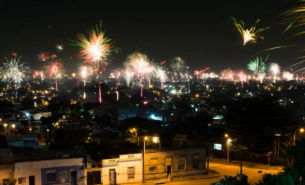 weihnachten in uruguay. eine feierliche weihnachtsszene in uruguay mit sommerlicher straßendekoration, fröhlichen menschen bei einer open-air-party und feuerwerk.